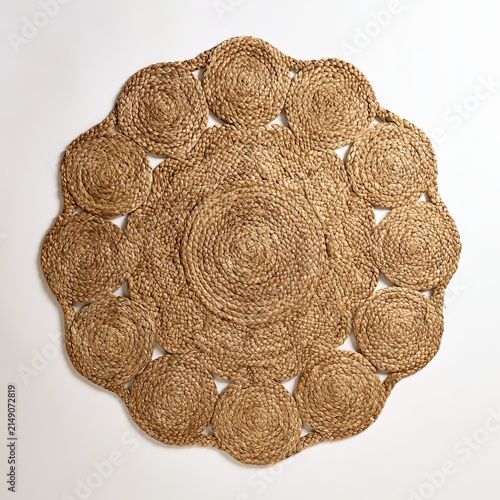 Wicker rug sits against white background.