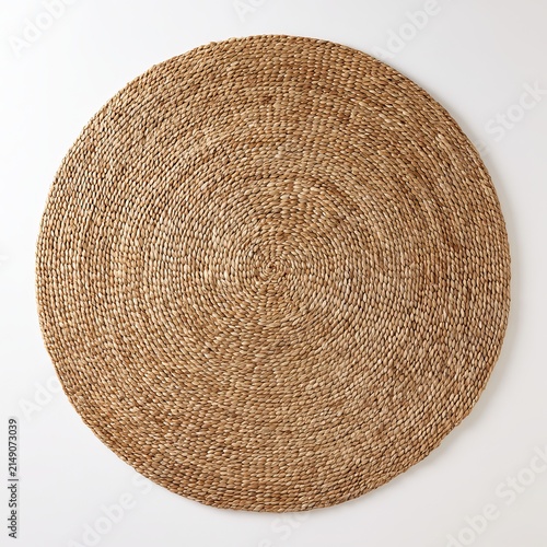 Wicker rug sits against white background.