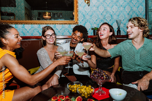 Fotografía Diverse friends enjoying cocktails and toasting during a social party