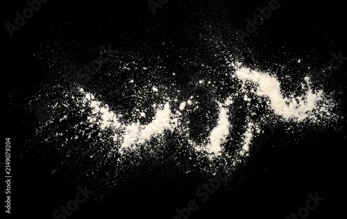 Photography White flour or powder scattered in a flowing shape on a black background, creating a dramatic contrast with a messy textured look and strong copy space