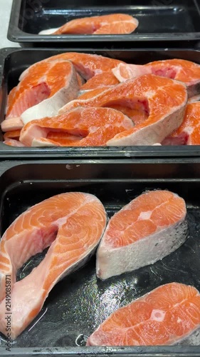 Chilled chum salmon steaks from frozen raw materials on a substrate for sale in a supermarket. Close-up