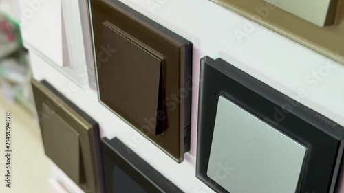 Close-up colorful electrical switches on display showcasing sample board with multiple finishes and colors glossy black, matte