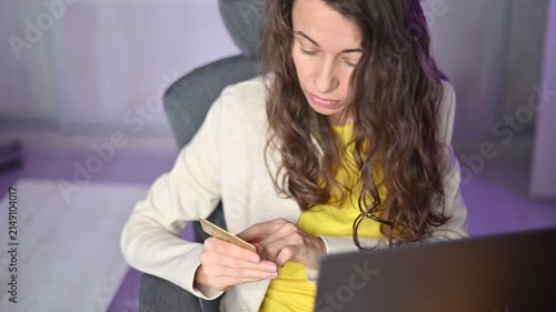 Happy woman entering credit card details on her smartphone for online shopping and payment in a at night modern office