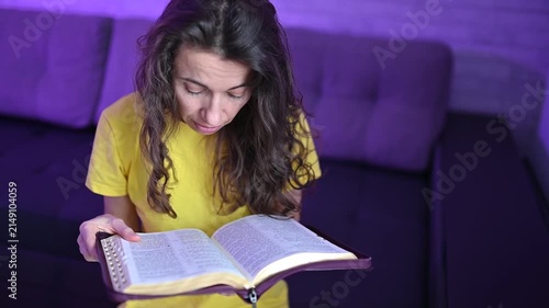 Woman reading the bible and turning pages Devout christian studying scripture and deepening faith at home