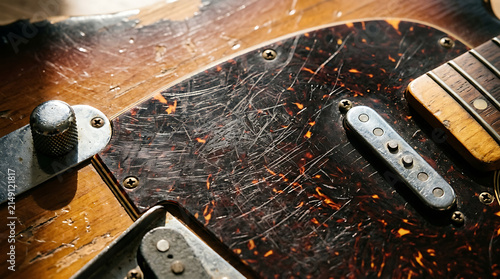Close-up of a scratched tortoiseshell electric guitar pickguard showing signs of extensive use and character