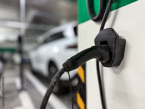 Modern Electric Vehicle Charging Station with Cable in Urban Parking Garage