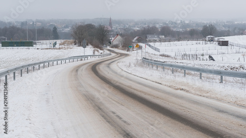 SNOWY WINTER - A snow-covered local road and a small regional town in a winter landscape
