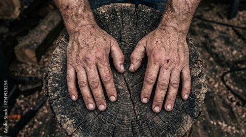 Dirty scratched hands of a carpenter rest on a cracked wooden stump in a dark workshop. Concept manual labor, workplace safety, skilled trade and occupational health advertising. Generative AI.