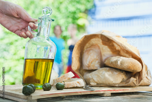 Italy, Tuscany, Magliano, Close up of bread, olive oil and olives on wooden table