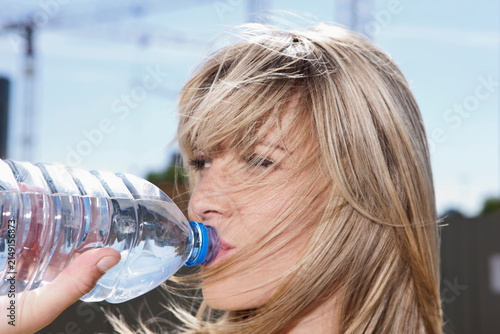 Close-up of a young woman in Cologne, Germany, quenching her thirst with a refreshing drink of water