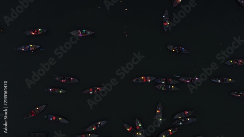 High-angle view of many small boats carrying people with colorful glowing lanterns at night
