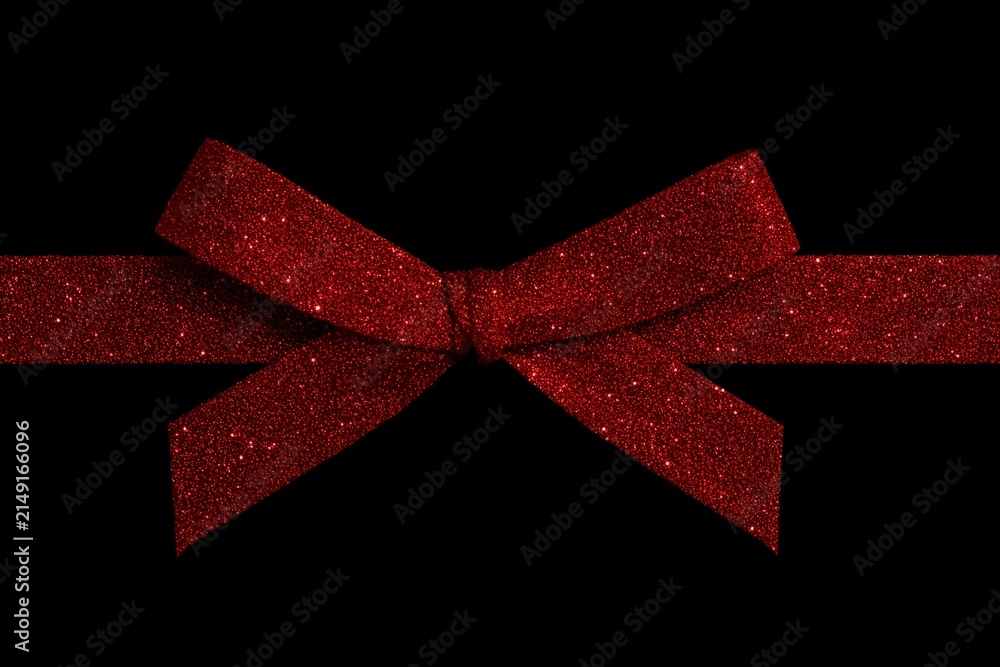 Naklejka premium Red glittery ribbon bow on a black background