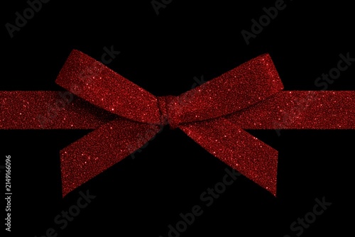 Red glittery ribbon bow on a black background