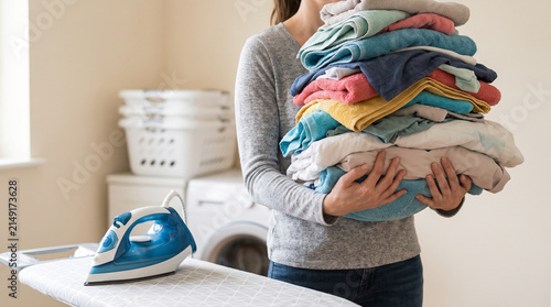 Person holding colorful folded clothes at home, symbolizing laundry, housekeeping, family responsibility, organization, and household management.