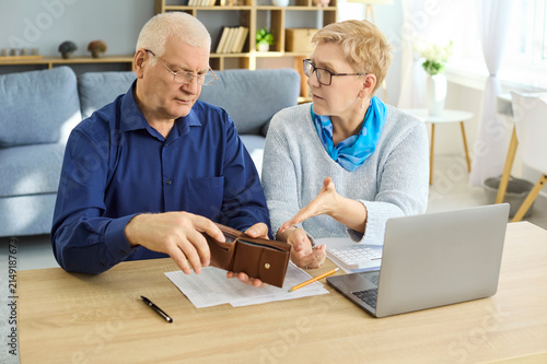Cuadro en lienzo Seniors couple budgeting with empty wallet and bills