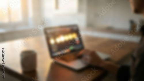 defocused person working on laptop with warm light for fintech