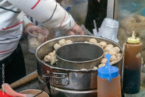Canvas Print Large metal pot holds meatballs either steeped in broth or steamed which are often served alongside dumplings, tofu, and noodles