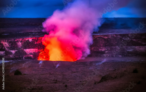Canvastavla Active Kilauea volcano crater erupting with molten lava and volcanic gases against a dark stormy sky