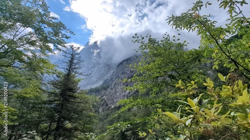 Mystical fog rolling over green mountain peaks in scenic Logar valley Slovenia