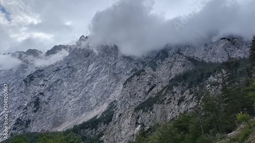 Mystical fog rolling over green mountain peaks in scenic Logar valley Slovenia
