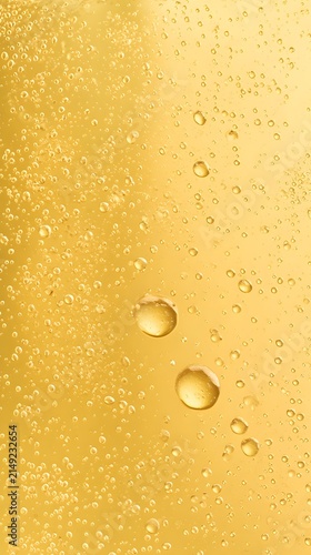 Condensation Drops on Cold Beer Glass. Abstract yellow background of cold beer close-up. Beer Gold Liquid with Floating Bubbles