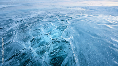 Ice patterns cover the frozen surface of a deep lake creating unique geometric natural textures.