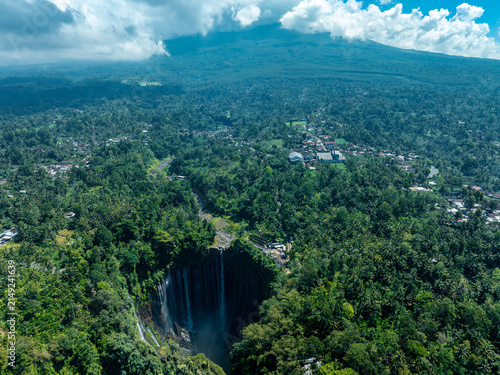 The breathtaking view of Tumpak Sewu Waterfall, surrounded by lush tropical forests in East Java, Indonesia.