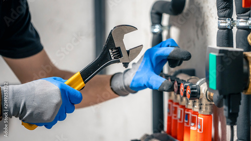Professional Plumber Installing and Adjusting Residential Heating System Valves for Efficient Home Performance