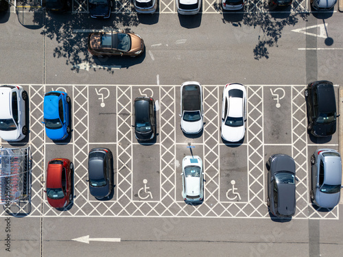 Aerial view of a parking lot with various cars parked in designated spaces including marked disabled parking spots in London, England, United Kingdom.