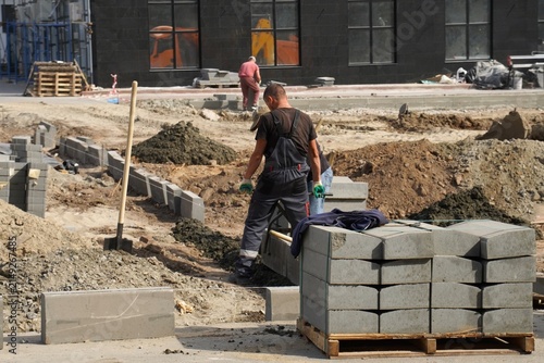 Fotografía Construction workers engaged in paving and building infrastructure at an urban site