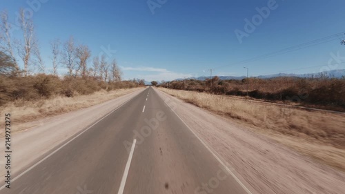 Car forward view driving on straight paved road in Salta Argentina. Drone - flying