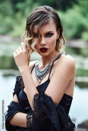 Elegant Woman Posing Outdoors with Dramatic Makeup