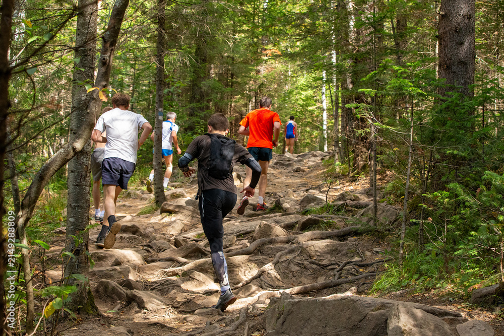 Obraz premium Group runners is running marathon race in uphill over stones