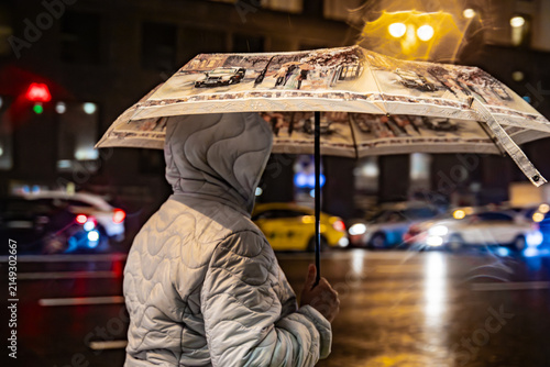A man with an umbrella on an evening city street