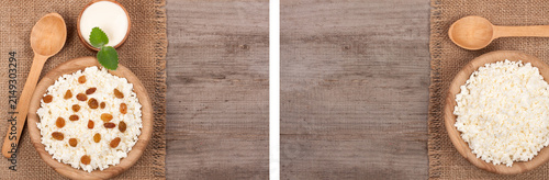 Cottage cheese in bowl with sour cream and raisins on old wooden background with copy space for your text. Top view