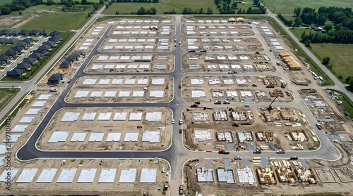 Aerial view of housing development construction with foundations and framing underway