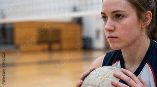 Young female volleyball player focused on the ball during a game in a gymnasium
