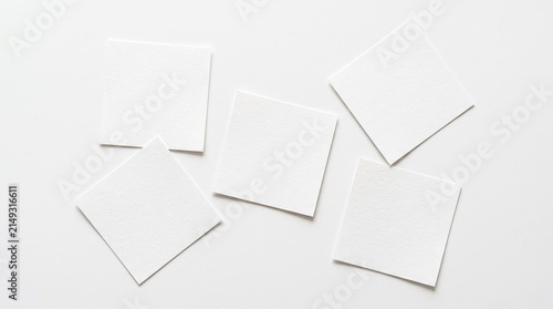 Five scattered blank square white paper cards flat lay mockup