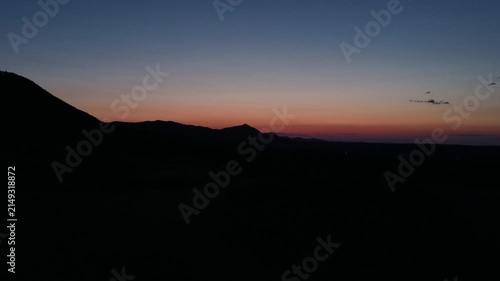 Drone view amazing evening Carpathian mountains. Great mountain range with colorful clouds from bird's eye view. Aerial footage of green forests at night time. Beauty of earth