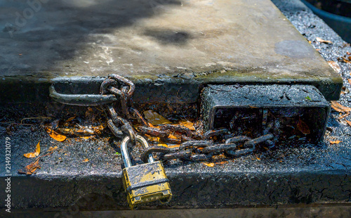Closeup of Lock and Chain on Top of a Grimy Outdoor Grease Trap