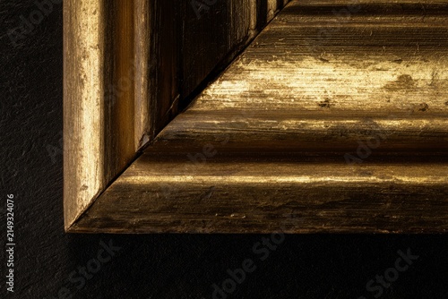 Worn gold leaf on antique picture frame corner, heritage and preservation concept
