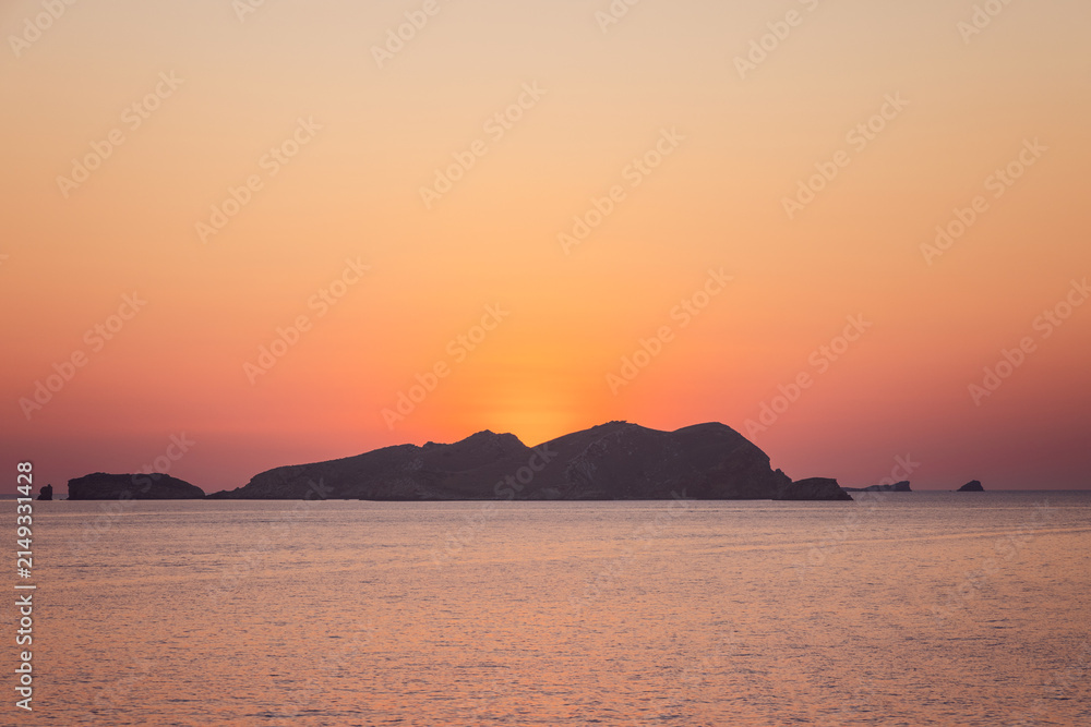 Fototapeta premium Sa Conillera occupies this composition from Platges de Comte on Ibiza, Spain with afterglow, lit by soft post sunset ambient glow.