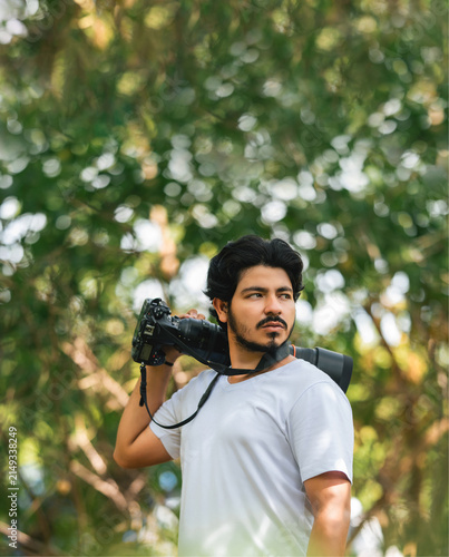 Bild auf Leinwand Portrait of a nature photographer carrying a professional camera outdoors