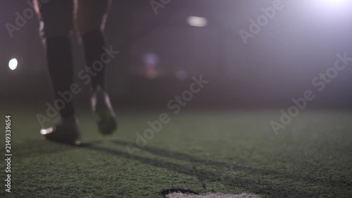 American football player kicks the ball with his foot.