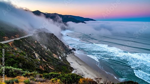 Coastal mountains with thick fog and ocean waves.