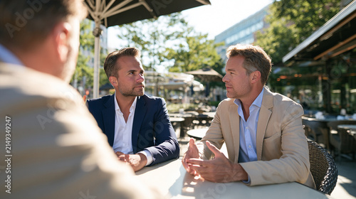 Financial Consultant Listening to Client During Private Business Conversation at Outdoor Cafe