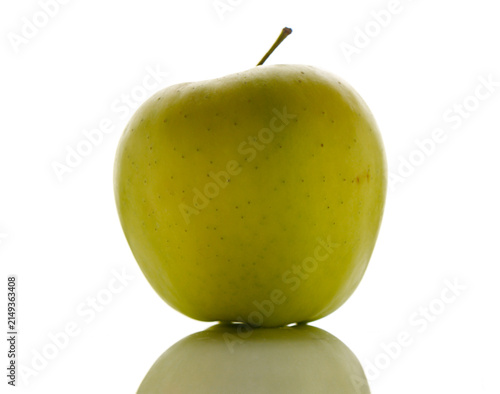 Фотография Vibrant green apple standing on a reflective surface under bright light creating