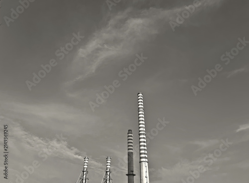 monochrome view of four industrial chimneys in a power plant against the sky