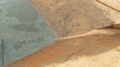 An industrial waste water is draining into public sewer. Representing urban water pollution, sewage system management. Environmental impact from industrial activity
