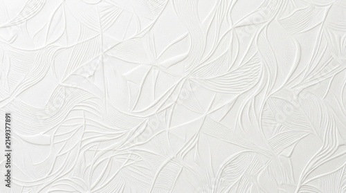 A white ceramic tile features a textured, embossed pattern resembling stylized leaves.